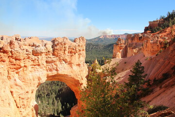 Hoodoo arch with behind is smoke from the wild fire.