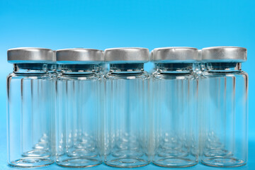 side view empty vaccine bottles on blue background