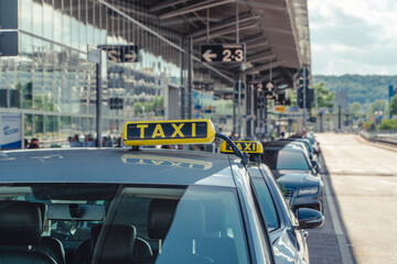 A german taxi waiting in front of an airport for customers.