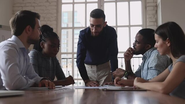 Happy male executives give high five at group meeting express effective solution business agreement partnership, friendly colleagues celebrate successful good teamwork result at diverse team briefing