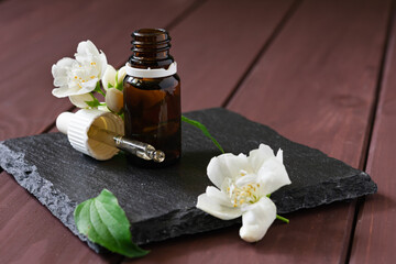 natural cosmetic product, jasmine oil with glass bottles on a wooden table