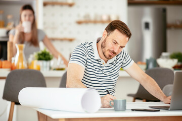 Young man working on project. Handsome man working at home.	