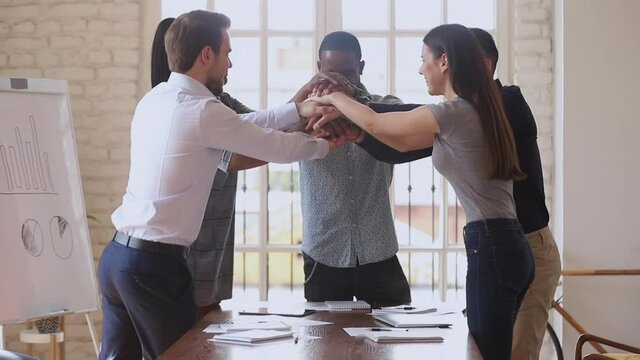 Happy multiracial business team people group stack hands together motivated by corporate success promise partnership union help support in teamwork engaged in teambuilding celebrate victory concept