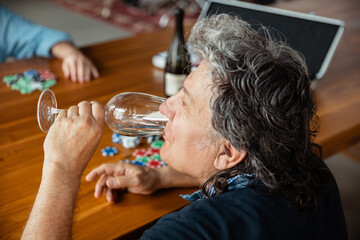 Exciting. Happy mature man drinking wine with friends during card game. Looks delighted, excited. Caucasian man gambling at home. Sincere emotions, wellbeing, facial expression concept. Good old age.