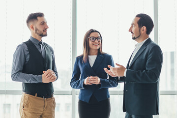 Three successful business people talking in office.