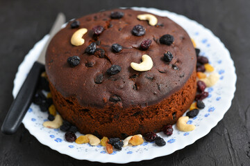 Plum cake made with dried fruit, raisins, cashew nuts, almond etc. Tasty home made cake flavored with cinnamon and spices for sale on Christmas and new year Kerala India.