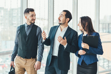 Happy business people standing side by side, smiling, enjoying time in such a team.
