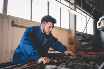 Pensive auto mechanic looking for engine malfunction problem. Car repair concept
