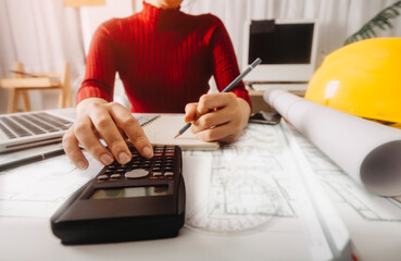 Two colleagues discussing data working and tablet, laptop with on on architectural project at construction site at desk in office