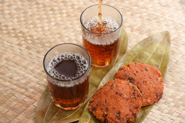 Cup of black tea and heap of dried organic tea leaves, dust and infuser  Munnar, Kerala, India. Aromatic herbal Indian beverage for relaxation, stress relief. healthy drink has antioxidants, nutrients