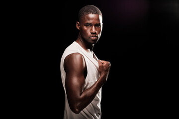 black man in profile position looking at camera wearing a white shirt and stretching his t-shirt