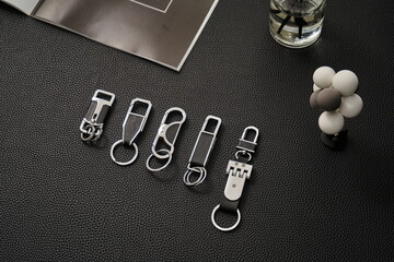 A bunch of car keychains on a black leatherette background