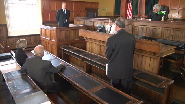 Witness being questioned by a Male Barrister / Attorney in Court or Courtroom. USA Flag. Stock Video Clip Footage