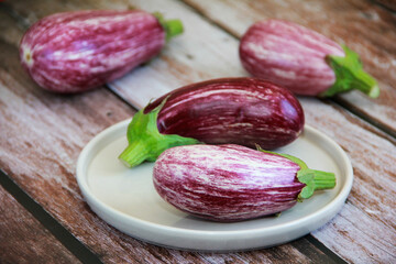 natural striped eggplant fruits on a decorative plate