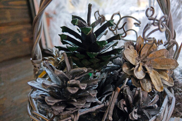 A small basket with spruce and pine cones. Selective focus.