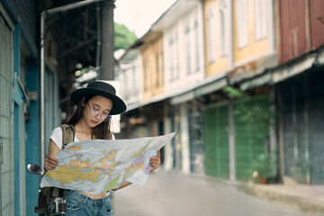 Girl holding a world map and traveling with a camera