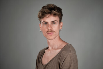 Fototapeta na wymiar Selective focus portrait of a young blond man with blue eyes and mustache