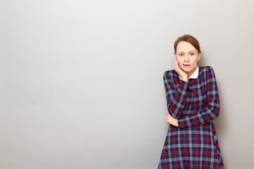 Obraz premium Portrait of unhappy shocked frightened girl touching cheek with hand