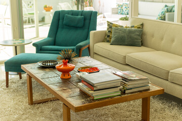 Sunny mid-century modern 1950s home living room interior in Palm Springs California with coffee table, books, sofa