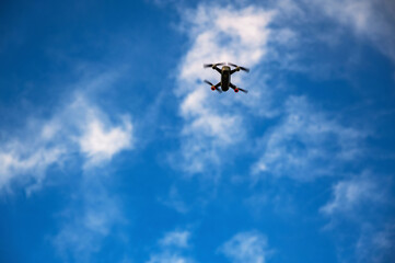 Naklejka na ściany i meble Drone flyin high in clouds.