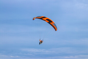 Paraglider with motor and parachute. Flying man on a paraglider.