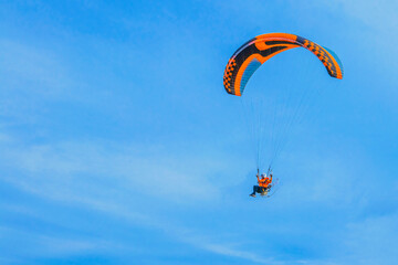 Paraglider with motor and parachute. Flying man on a paraglider.