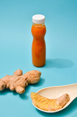 Obraz premium Ginger in different conditions: fresh, dry root, pills and cut plant on pastel blue background. Flat Lay, space for text. Healthy pattern as a protect agains the coronavirus