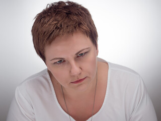 Portrait of woman with intense, inscrutable expression on her face. Young caucasian woman with...