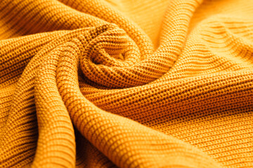 Wool background. Abstract fresh colorful yellow knitted pattern background texture. Orange knitted pattern of acrylic yarns, closeup.