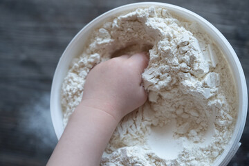 Children's hand in flour, top view.
