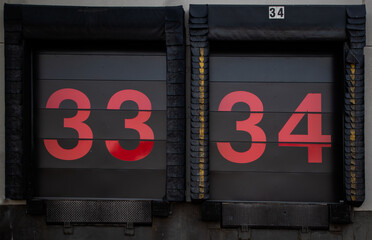 A pair of numbered warehouse truck bins with big 33 and 34 digits on the doors
