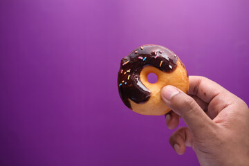 Close up of hand holding donuts .