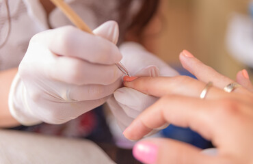 Obraz na płótnie Canvas Nails painting on manicure. Woman in beauty spa salon doing manicure 