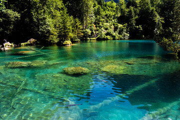 A magnificent crystal clear blue lake in the mountains. Swiss Alps. Summer mountain landscape. Blue water.