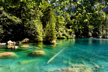 A magnificent crystal clear blue lake in the mountains. Swiss Alps. Summer mountain landscape. Blue water.