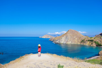 June 14, 2018 - Labuan Bajo, Komodo National Park, Indonesia : Asian girl in red cardigan enjoying view of Padar Island.