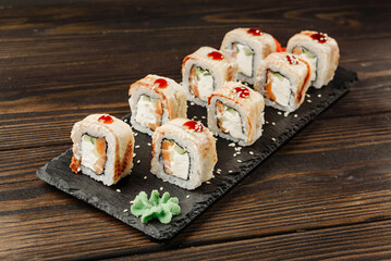 Set of rolls on a black dish with wasabi.