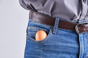 caucasian male person with egg at his jeans pocket. potency mens health concept. copy space.