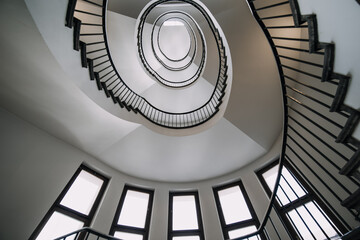 looking deep into long spiral stair case of big building