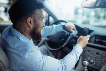 Man driving a car and holding mobile phone. Driver man using mobile phone while driving a car.