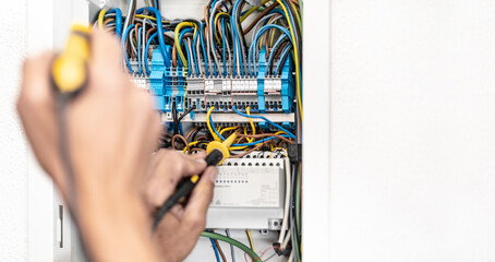 Elektriker prüft den Durchgang einer Leitung am Sicherungskasten 