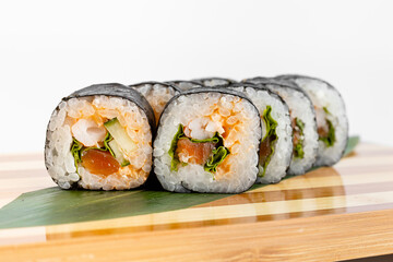 Maki Sushi Rolls set on wooden bamboo board. Japanese traditional Cuisine. White background.