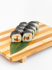 Maki Sushi Rolls set on wooden bamboo board. Japanese traditional Cuisine. White background.