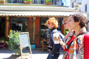 Young women walking with coffee cup at sunlight day in the street of Istanbul, Happy faces and...