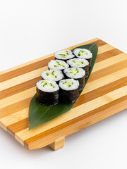 Maki Sushi Rolls set on wooden bamboo board. Japanese traditional Cuisine. White background.