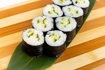 Maki Sushi Rolls set on wooden bamboo board. Japanese traditional Cuisine. White background.