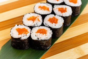 Maki Sushi Rolls set on wooden bamboo board. Japanese traditional Cuisine. White background.