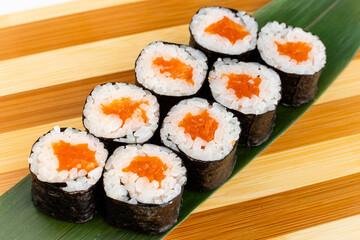 Maki Sushi Rolls set on wooden bamboo board. Japanese traditional Cuisine. White background.