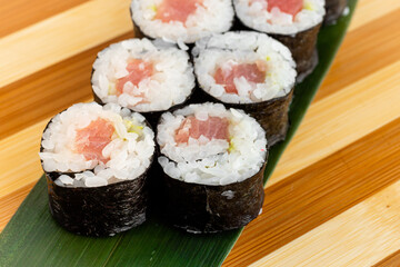 Maki Sushi Rolls set on wooden bamboo board. Japanese traditional Cuisine. White background.