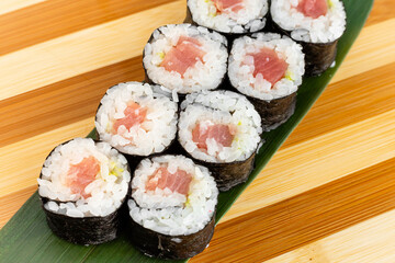 Maki Sushi Rolls set on wooden bamboo board. Japanese traditional Cuisine. White background.